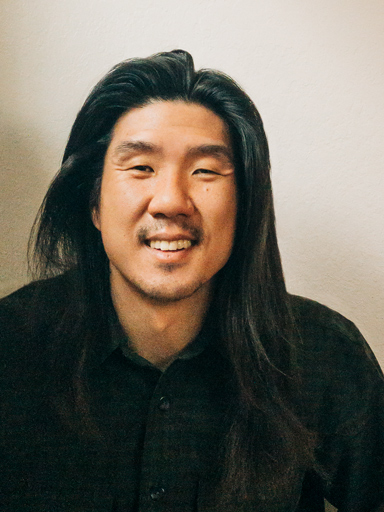 Photo portrait of Jay, with a big smile, looking at the reader.