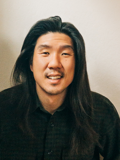 Photo portrait of Jay, with a big smile, looking at the reader.