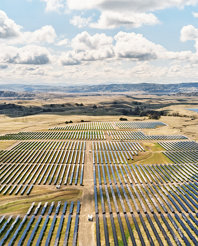 Prise de vue aérienne d’une vaste plaine parsemée de panneaux solaires produisant de l’énergie.