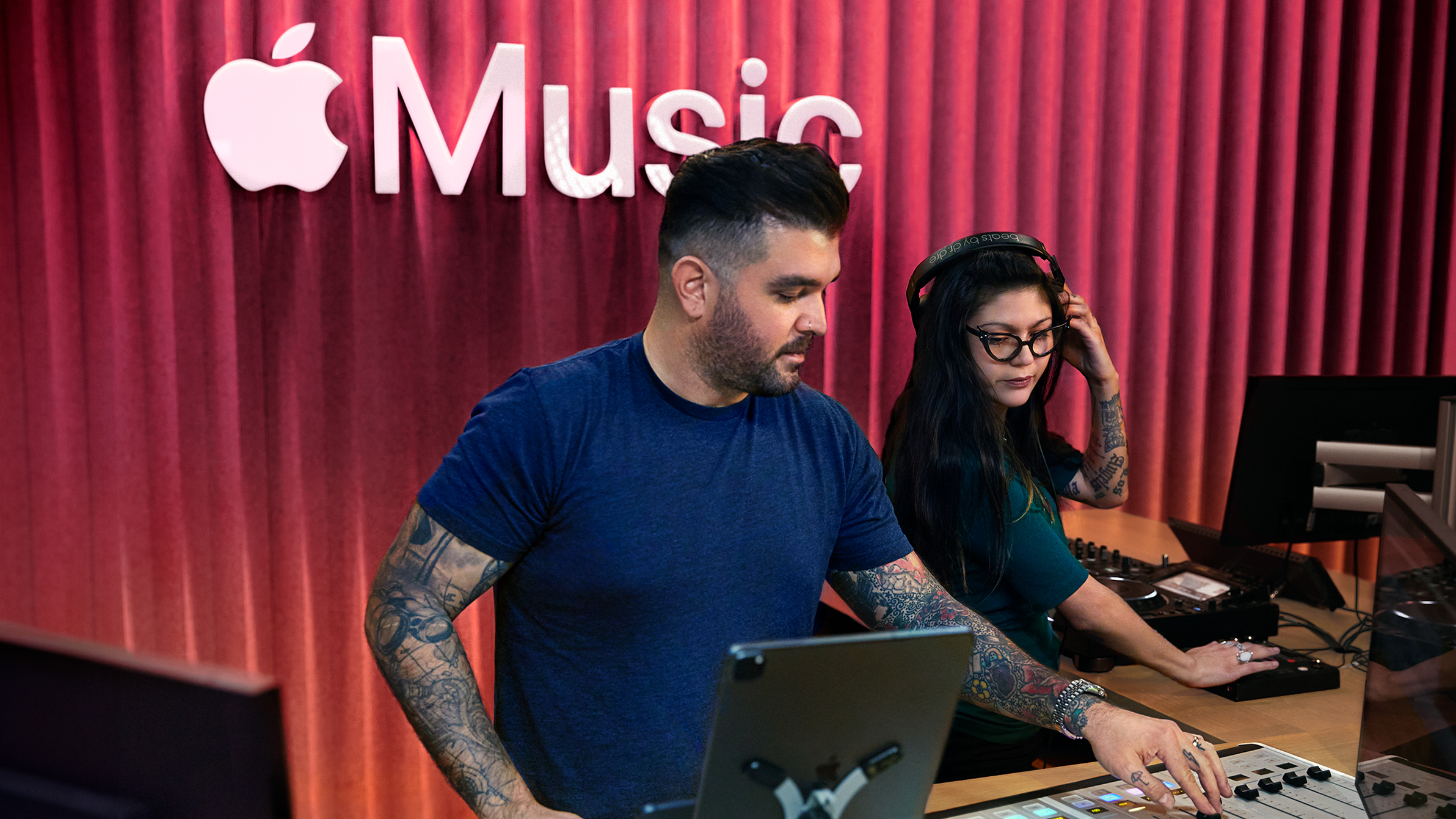 Deux membres de l’équipe Apple utilisent une table de mixage dans un studio Apple Music.