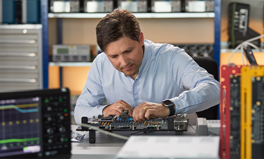 Greg working in a hardware engineering lab, surrounded by silicon testing equipment.