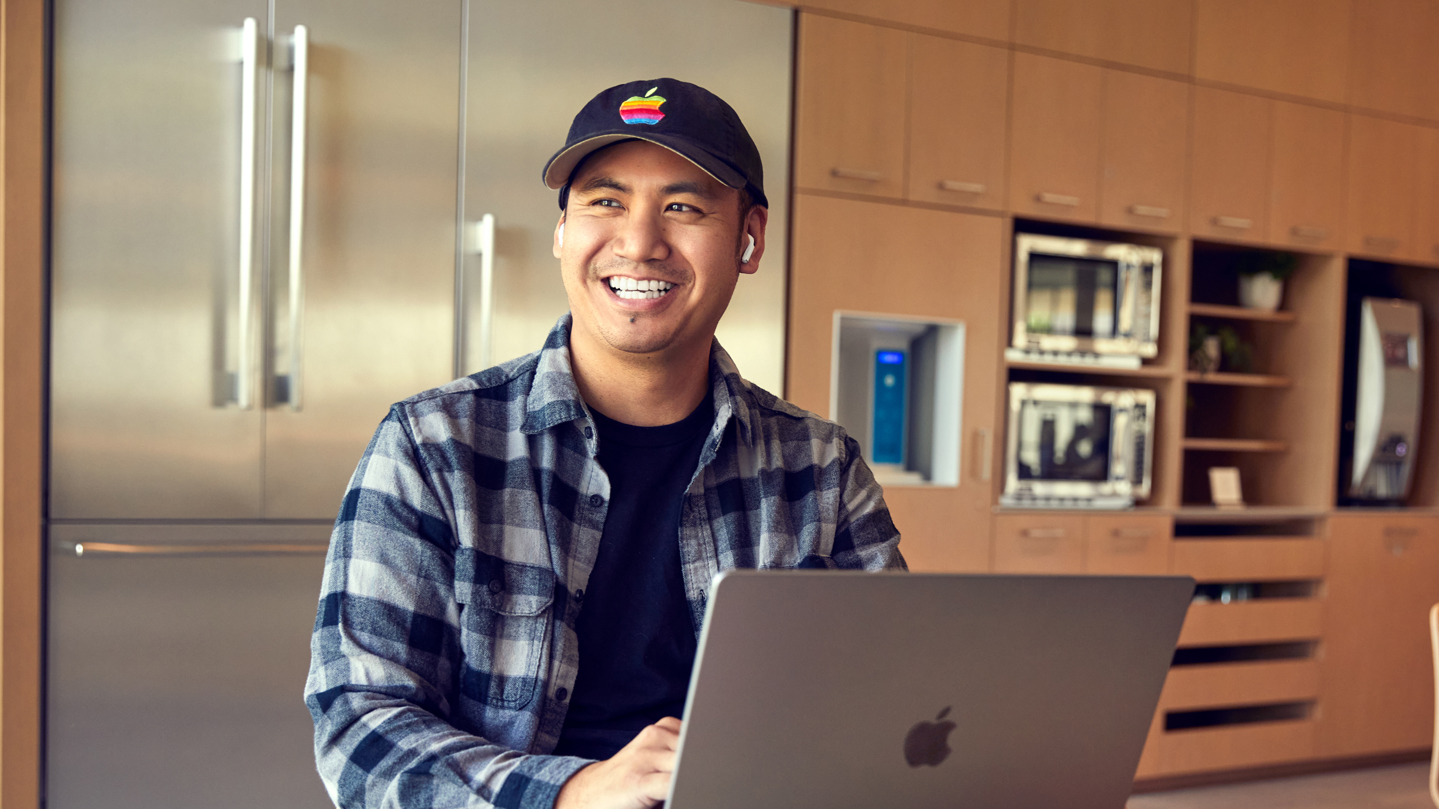 Un employé d’Apple San Diego sourit en travaillant sur son portable.