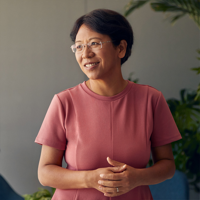 Jean, souriante, le regard tourné vers le côté.