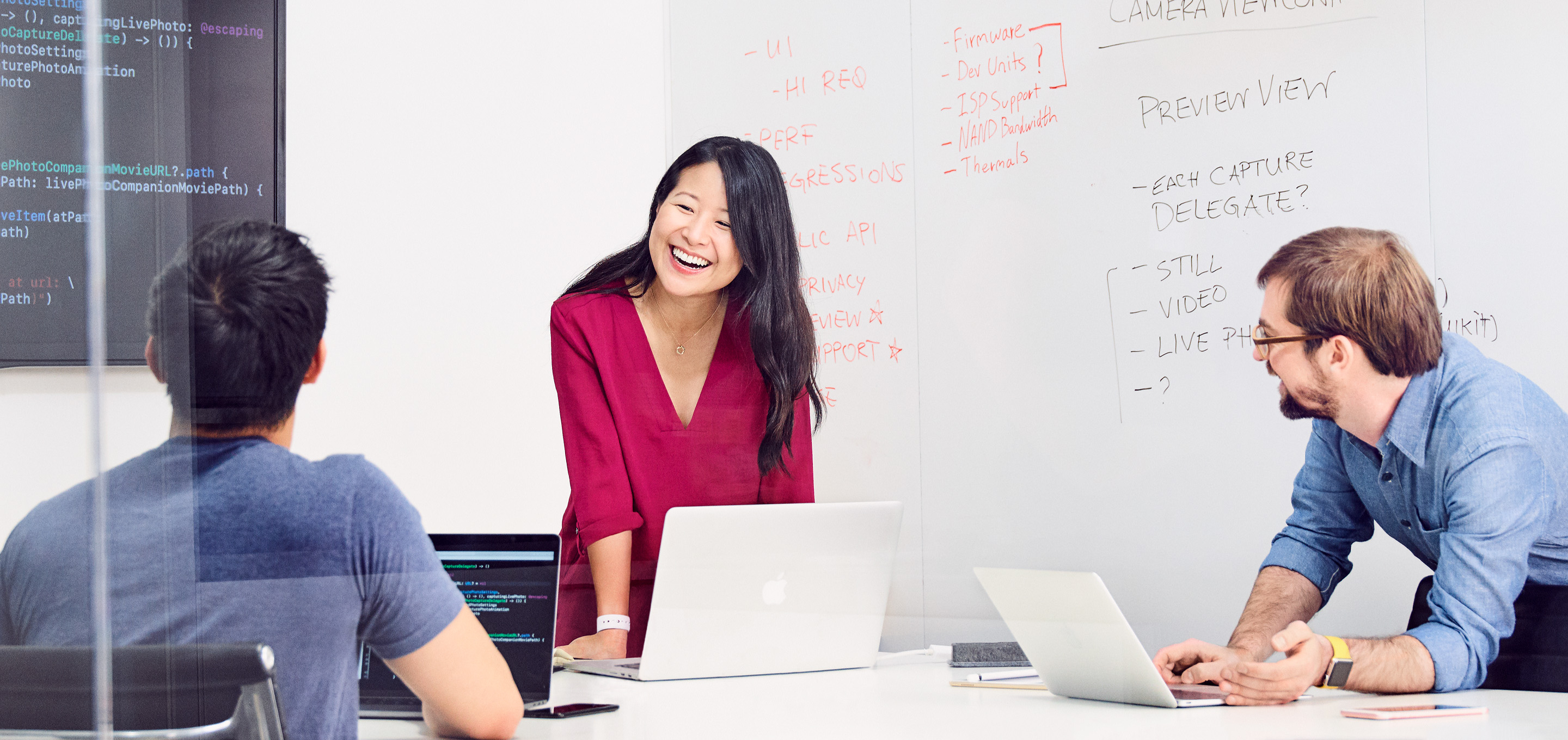 A group of Apple software engineers discuss a project in a conference room