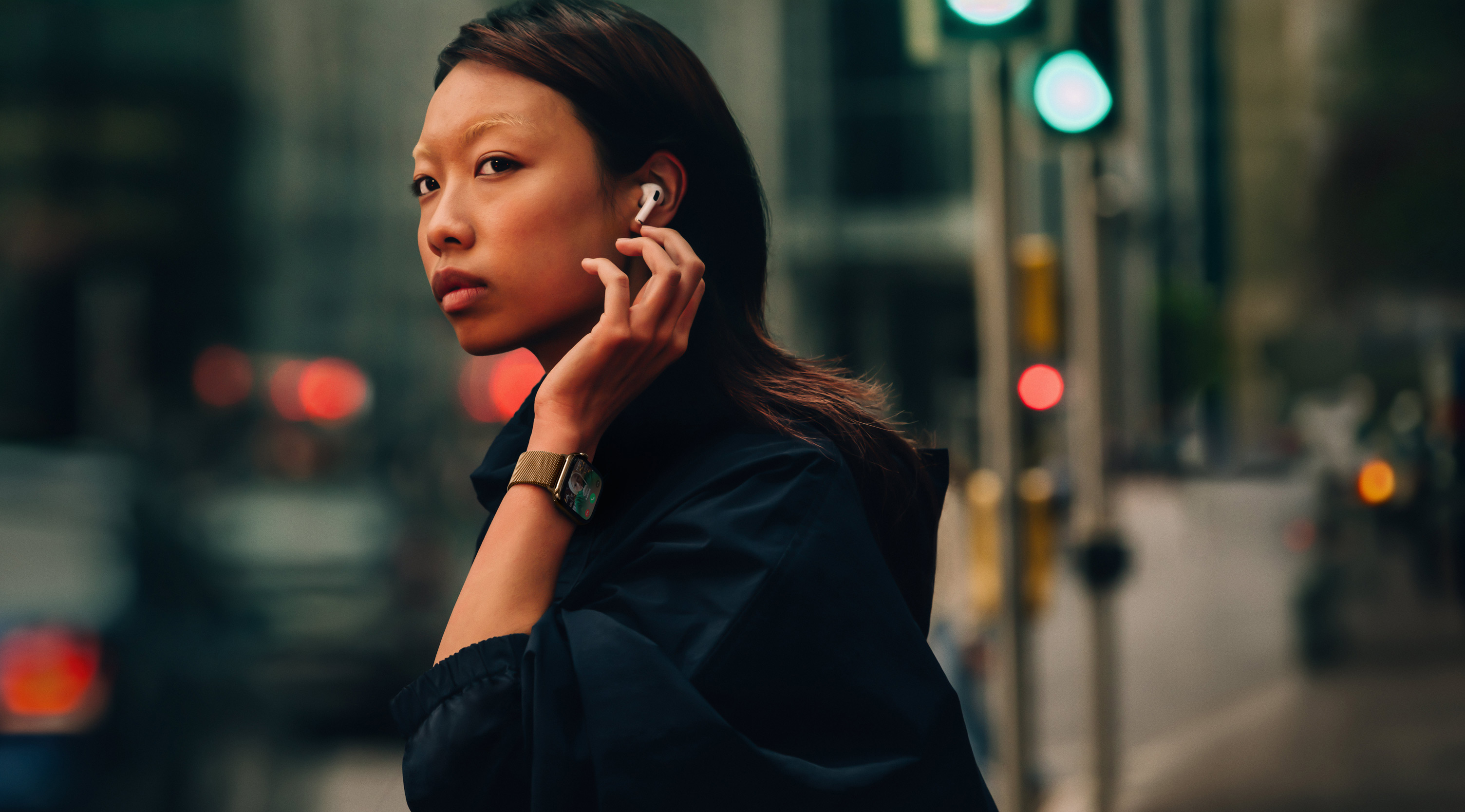 Eine Frau auf der Straße, die eine Apple Watch Series 10 und AirPods trägt.