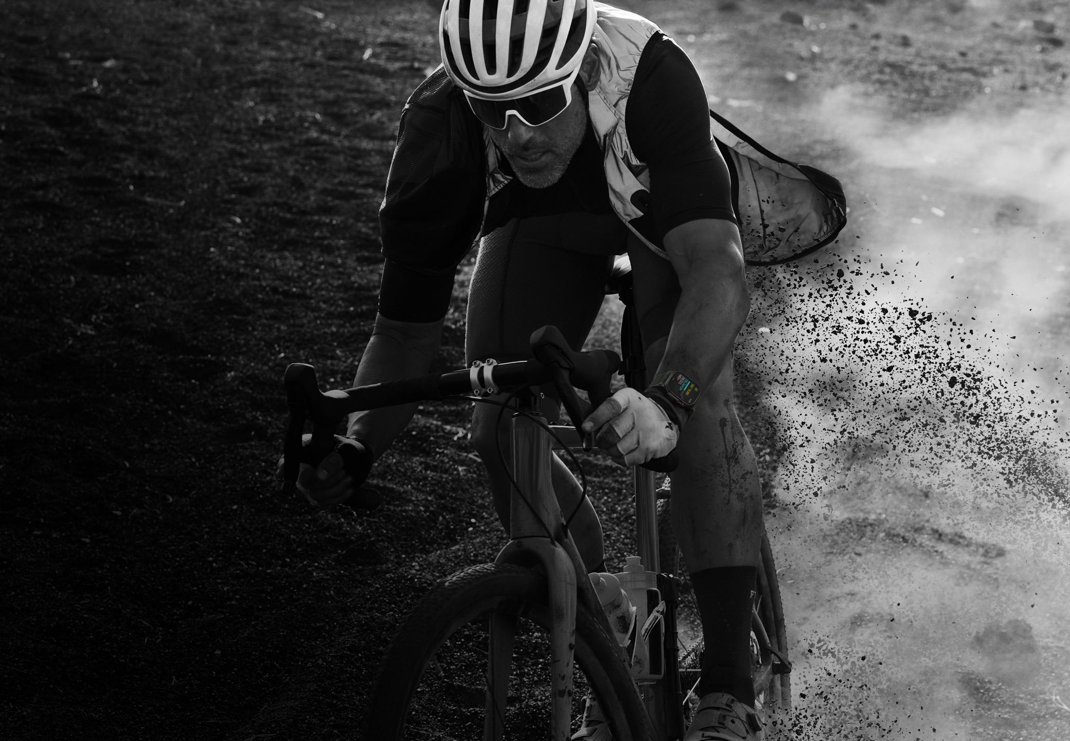 Una persona en bici que pedalea por terreno rocoso y lleva puesto un Apple Watch Ultra 2.