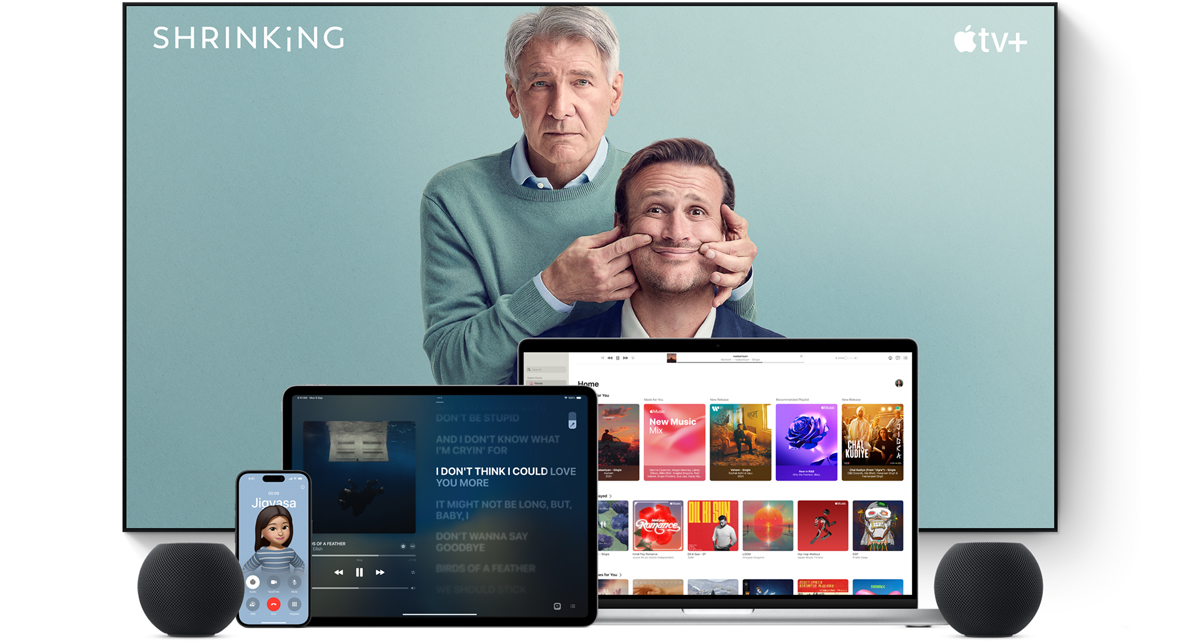 Large TV screen showing a coach behind two microphones. A MacBook Pro, an iPad, an iPhone, and a Space Gray HomePod mini are arranged in front.