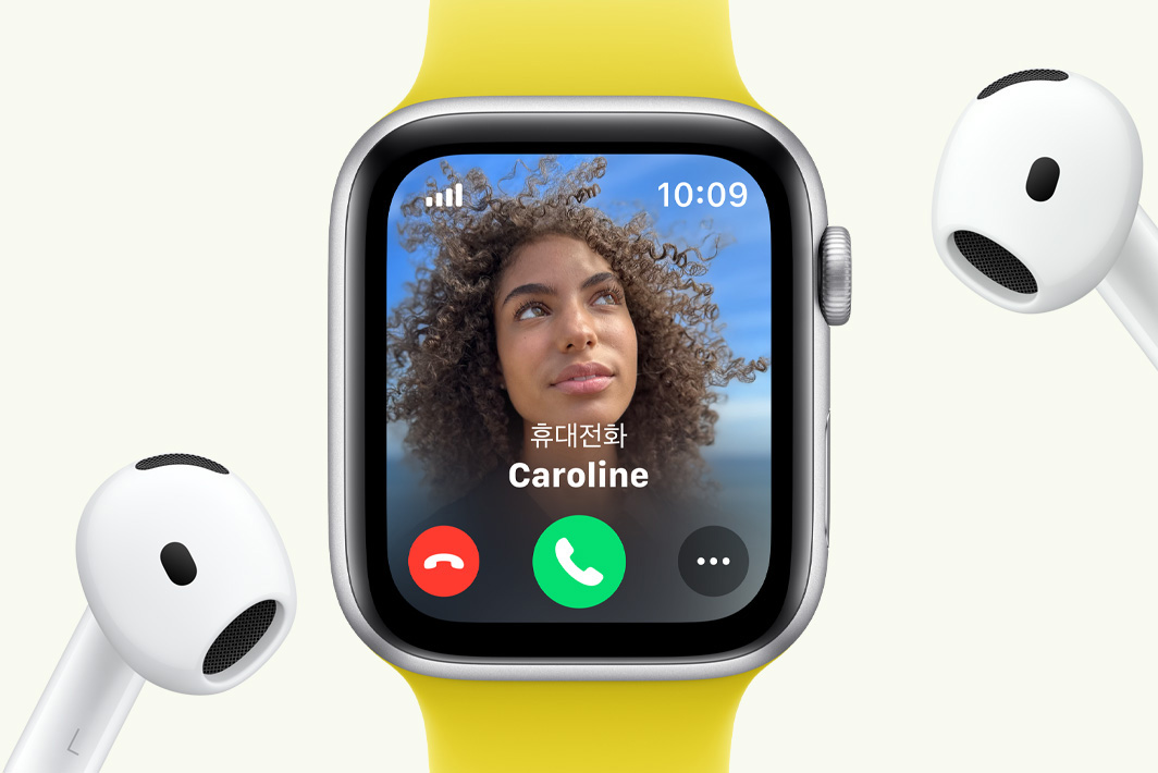 전화가 걸려 오는 Apple Watch SE와 그 옆에 한 쌍의 AirPods이 있는 모습