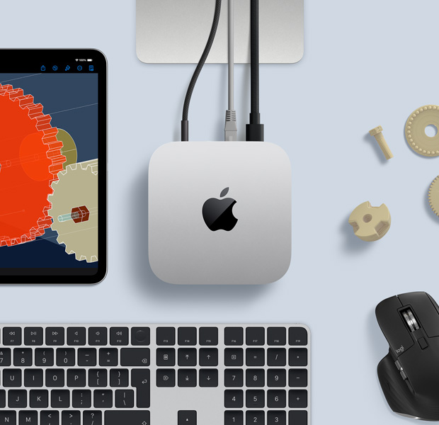 Top view of silver Mac mini in a desk setup with a black-and-silver wireless keyboard, a black wireless mouse, and an iPad