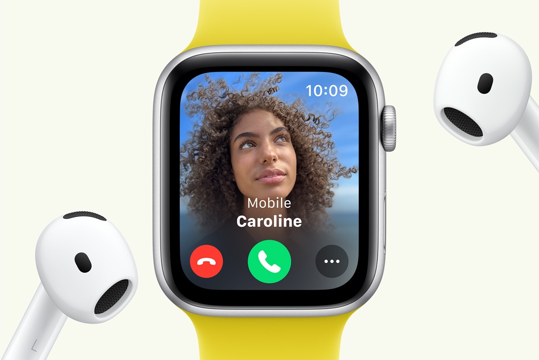 Apple Watch SE showing an incoming call, next to a pair of AirPods