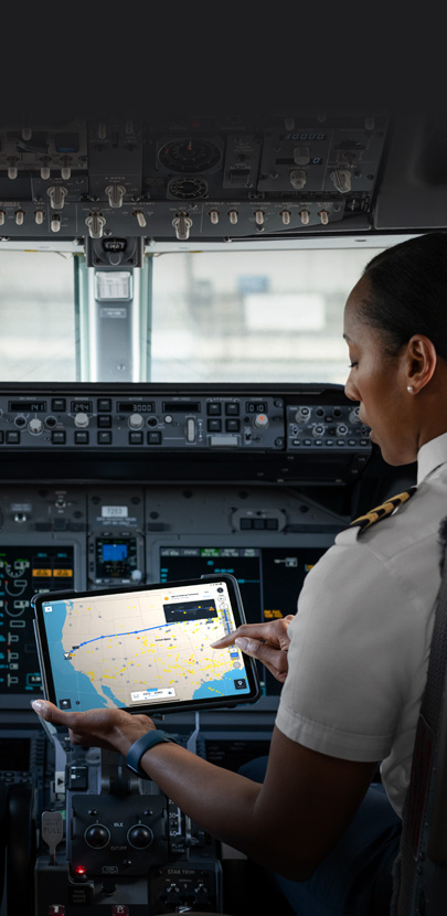 A pilot in a cockpit looking at a map on an iPad screen.