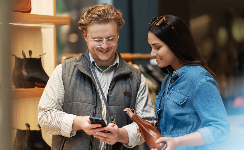 A sales associate uses iPhone on the shop floor to help a customer.