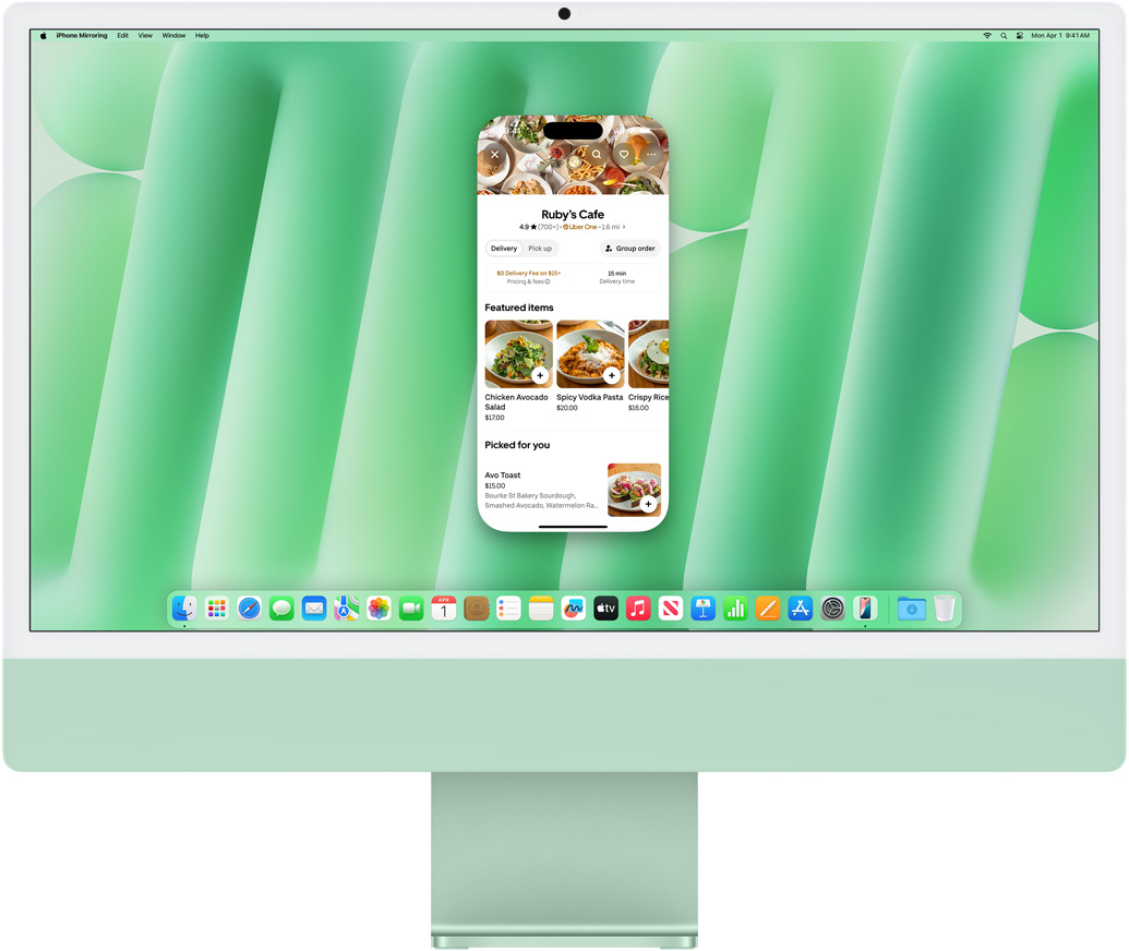 iPhone Mirroring feature demonstration. iPhone screen displaying Uber Eats app mirrored and controlled on iMac.