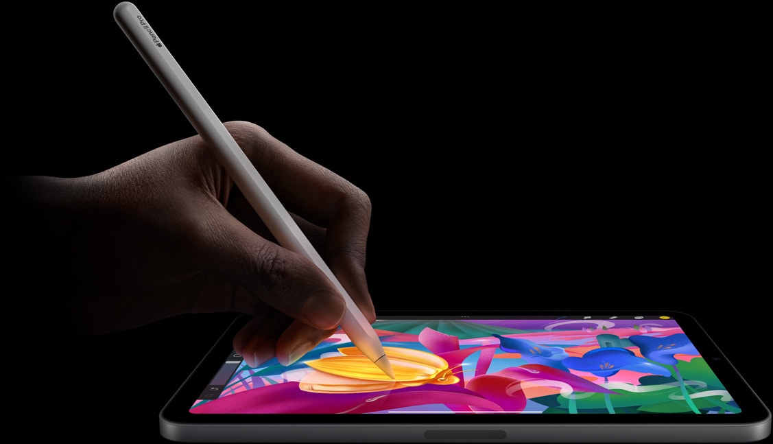 Tay của người dùng đang cầm Apple Pencil Pro tạo ra tác phẩm nghệ thuật đầy màu sắc trên iPad mini.