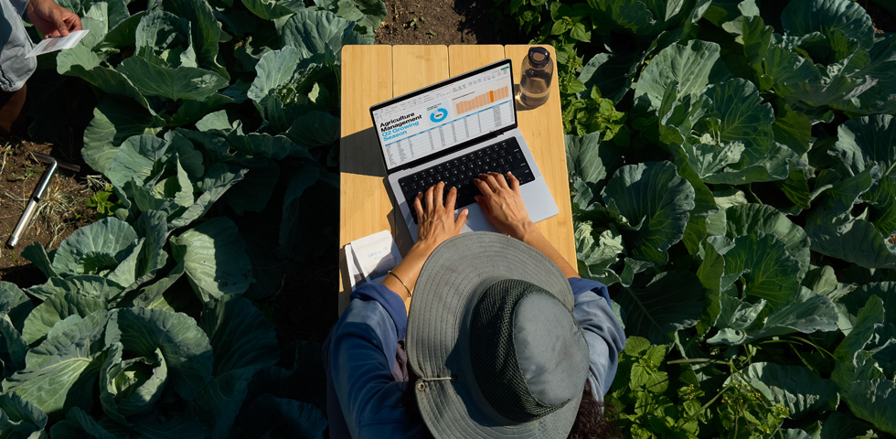 Una persona sentada al aire libre usa una MacBook Pro configurada con pantalla nanotexturizada, donde se aprecia la reducción del reflejo